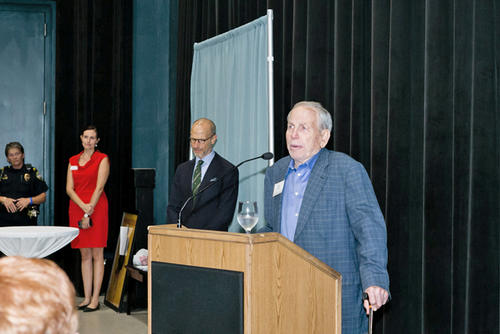 Ewing (right) speaks from the podium as Chancellor Bierman (2nd from right) looks down. Savannah Stanbery is visible (2nd from left).
