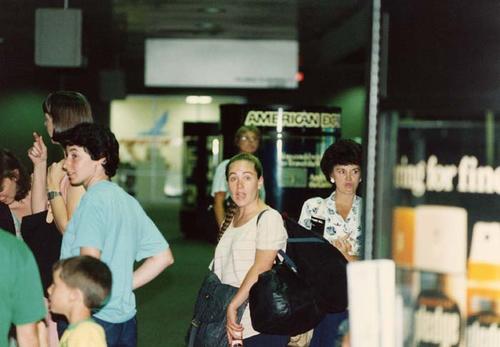 Students in airport; Mary Merritt (horn) facing camera