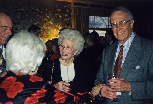 Ann Spencer (center) and Bob Cordell (right) listen to Earline King (foreground, back to camera) as an unidentified gentleman (left) looks on in the River Club of New York.